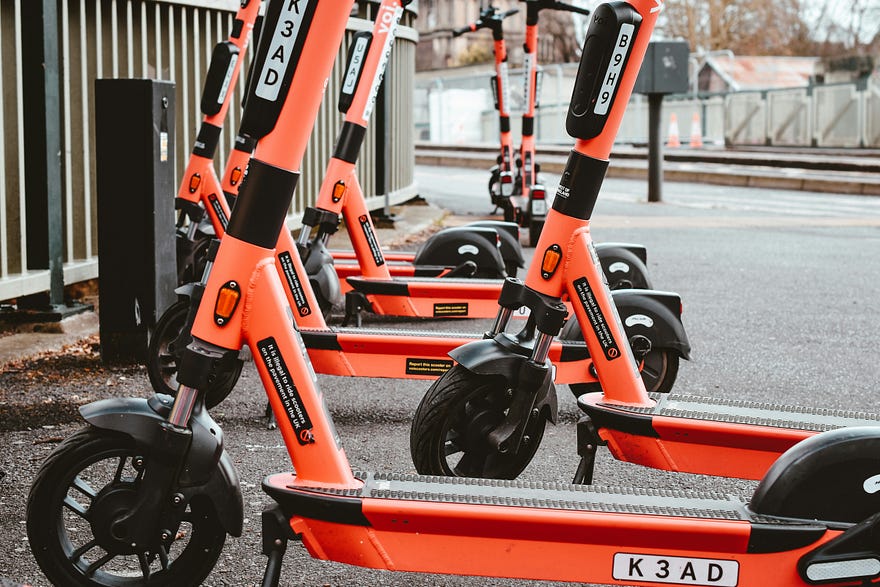 A group of electric scooters lined up ready for hire.