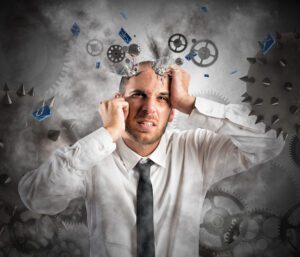 A man holding hid head with all sorts of question marks and exclamation marks floating around